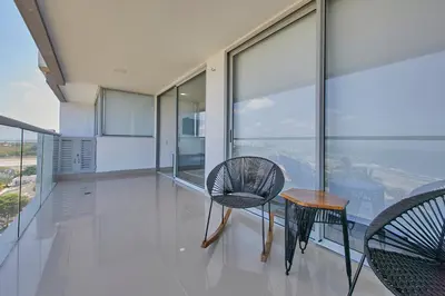 a room with a table and chairs on a balcony at Artsy Oceanview Condo W Incredible Rooftop Pool in Cartagena de Indias