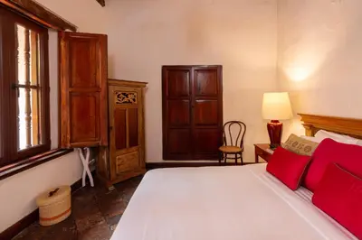 a bedroom with a bed with red pillows at Casa Baloco in Cartagena de Indias