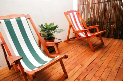 two rocking chairs sitting on a porch with a plant at Hostal Casa en la Ciénaga Rincon del Mar in Rincón
