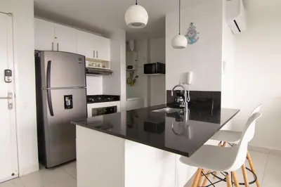 a kitchen with a black counter and a refrigerator at TU CASA EN MORROS 3 in Cartagena de Indias