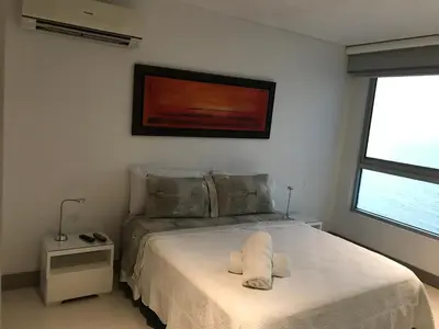 a bedroom with a bed with a white bedspread at Apartamento exclusivo frente al mar en Bocagrande in Cartagena de Indias