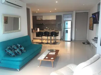 a living room with a blue couch and a table at Apartamento exclusivo frente al mar en Bocagrande in Cartagena de Indias