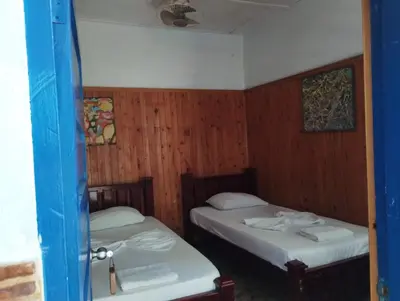 two beds in a room with wood paneling at Hostal Luna Llena Getsemaní in Cartagena de Indias
