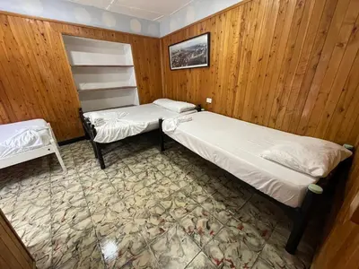 two beds in a room with wooden walls at Hostal Luna Llena Getsemaní in Cartagena de Indias