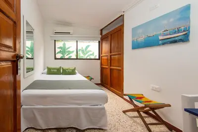 a bedroom with a bed and a chair at Hotel Ayenda Casa Cano 1805 in Cartagena de Indias