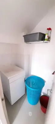 a white bathroom with a sink and a blue basket at Casa frente al mar con piscina in Coveñas