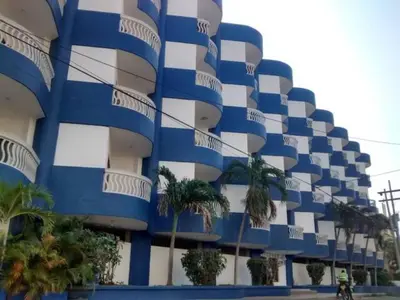 a blue and white building with palm trees in front of it at Santa Marta, Hermoso Apartamento Ubicado en Bello Horizonte in Santa Marta