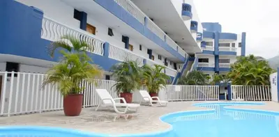 a swimming pool with two chairs and a building at Santa Marta, Hermoso Apartamento Ubicado en Bello Horizonte in Santa Marta