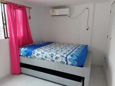 a small bedroom with a bed with a pink curtain at TITTO'S APARTMENT in Cartagena de Indias