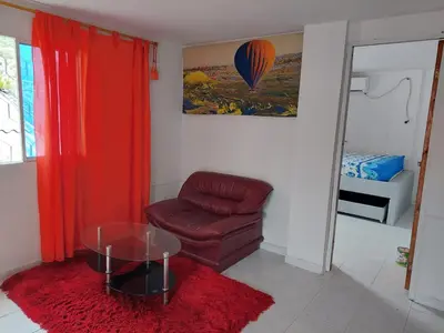 a living room with a chair and a glass table at TITTO'S APARTMENT in Cartagena de Indias