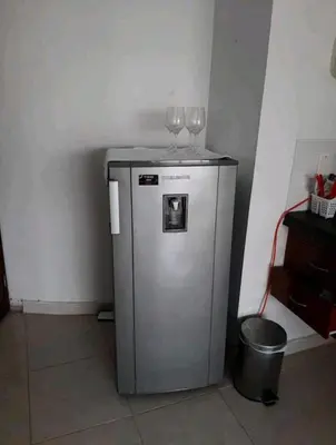 two wine glasses sitting on top of a small refrigerator at MR1-2G APARTAMENTO BASICO CERCA AL MAR CON AIRE ACONDICIONADO Y WIFi PARA 4 PERSONAS in Cartagena de Indias