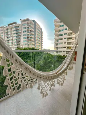 a hammock on a balcony with buildings in the background at Confortable y exclusivo apartamento en Martinique Cielo Mar in Cartagena de Indias
