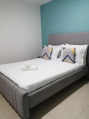 a bed with several pillows on it in a room at CC House Cartagena in Cartagena de Indias