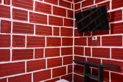 a red brick wall with a tv on a wall at Hostal La Guaca in Cartagena de Indias