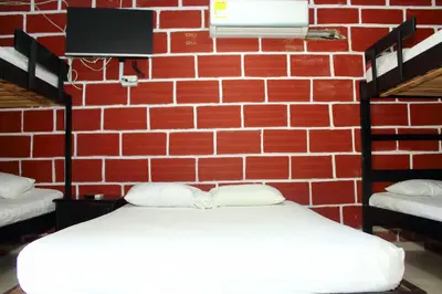 a room with a brick wall with two beds at Hostal La Guaca in Cartagena de Indias