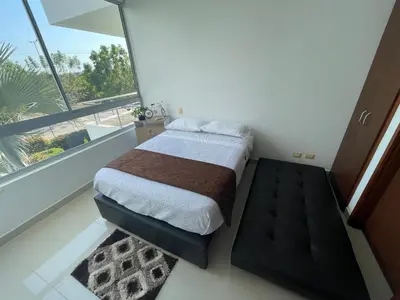 a bedroom with a bed and a large window at Condominio Campestre Laguna Club Cartagena in Los Arrayanes
