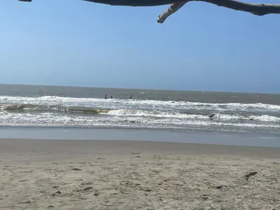 a beach with waves and people in the ocean at Condominio Campestre Laguna Club Cartagena in Los Arrayanes