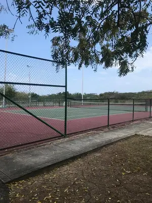 a tennis court with two tennis courts at Condominio Campestre Laguna Club Cartagena in Los Arrayanes