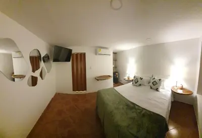 a hotel room with a bed and a tv at Candilejo Hotel Boutique in Cartagena de Indias