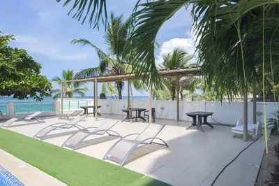 a patio with tables and chairs and the ocean at Magico Apartamento Frente al Mar 2 Habitaciones B11A in Coveñas