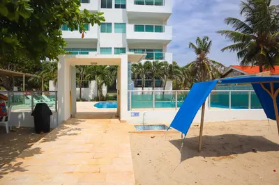 a building on the beach with a blue open door at Magico Apartamento Frente al Mar 2 Habitaciones B11A in Coveñas