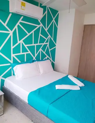 a bed in a room with a blue and white wall at Espectacular Apartamento cerca al centro Histórico in Cartagena de Indias