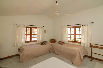 two beds in a room with two windows at Cabana Canaima in Coveñas