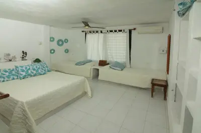 a white room with two beds and a window at Cabana Canaima in Coveñas