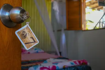 a door knob with a tag on it next to a bed at L' Europe in Isla Fuerte