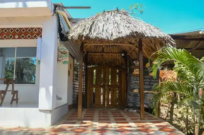 an open door to a hut with a straw roof at L' Europe in Isla Fuerte