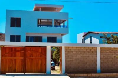 a house with two wooden garage doors in front of it at Cabaña Villas de Santa Veronica in Juan de Acosta