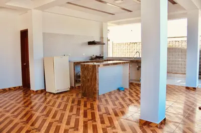 a kitchen with a refrigerator and a wooden floor at Cabaña Villas de Santa Veronica in Juan de Acosta