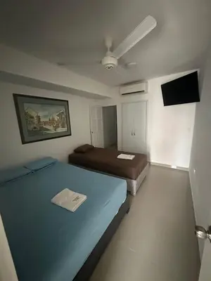 a small room with two beds and a flat screen tv at Apartamento in Cartagena de Indias