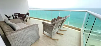 a balcony with chairs and a table and the ocean at Hermoso Apartamento frente al mar, 4 habitaciones - Apto 801 in Coveñas