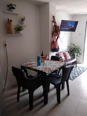 a dining room table with chairs and a table and a guitar at Encantadora casa con ambiente guajiro 2 in Barranquilla