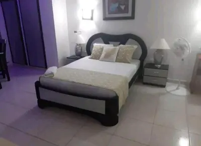 a bedroom with a bed and two lamps and a fan at Loft facing the sea MR1-2G upper class neighborhood in Cartagena de Indias