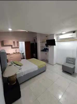 a bedroom with a bed and a tv and a chair at Loft in front of the sea MR1-1G neighbourhood strato alto in Cartagena de Indias