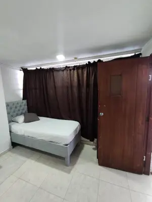 a bedroom with a bed and a wooden door at Loft in front of the sea MR1-1G neighbourhood strato alto in Cartagena de Indias