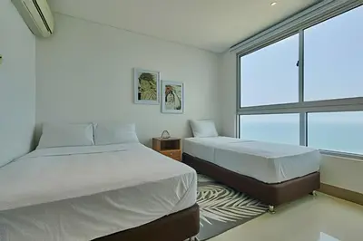 a bedroom with two beds and a large window at Laurdhomes Palmetto Beach Sew View, Hot Water in Cartagena de Indias