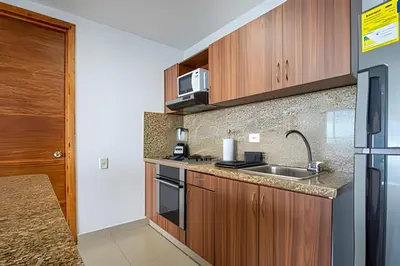 a kitchen with wooden cabinets and a sink at LaurdHomes Palmetto Sea View, 2Rooms 2BTH Hot Ware in Cartagena de Indias