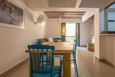 a dining room with a wooden table and blue chairs at Laurdhomes Duplex Old City, Plaza Santo Domingo in Cartagena de Indias