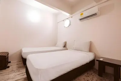 a small room with two beds and a table at Laurdhomes Duplex Old City, Plaza Santo Domingo in Cartagena de Indias