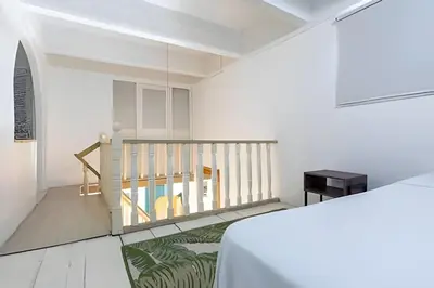 a white room with a staircase and a table at Laurdhomes Historic Center Plaza SantoDomingo 3Bth in Cartagena de Indias