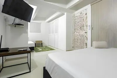a white bedroom with a bed and a television at Laurdhomes Historic Center Plaza SantoDomingo 3Bth in Cartagena de Indias