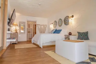 a white bedroom with a bed and a table at Bora Bora Beach Club Cartagena in Isla Grande
