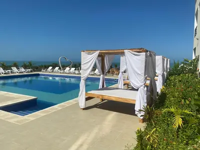 a gazebo by the swimming pool at a resort at Hotel Bahia Rada in Moñitos