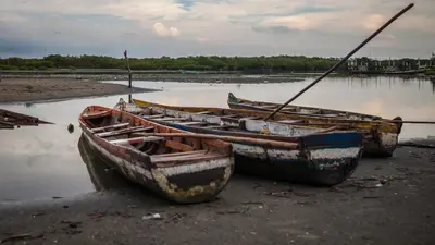 three boats sitting on the shore of a body of water at ORESCA Hostel in Cartagena de Indias