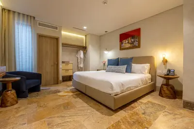 a bedroom with a bed and a couch and a chair at Hotel Voilá Centro Histórico in Cartagena de Indias