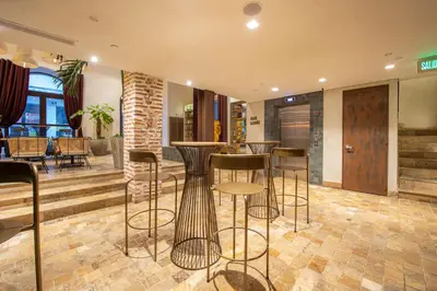 a bar with stools in a room with a table at Hotel Voilá Centro Histórico in Cartagena de Indias