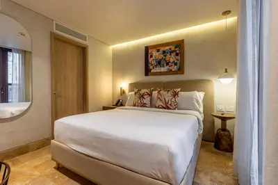 a bedroom with a large white bed and a window at Hotel Voilá Centro Histórico in Cartagena de Indias